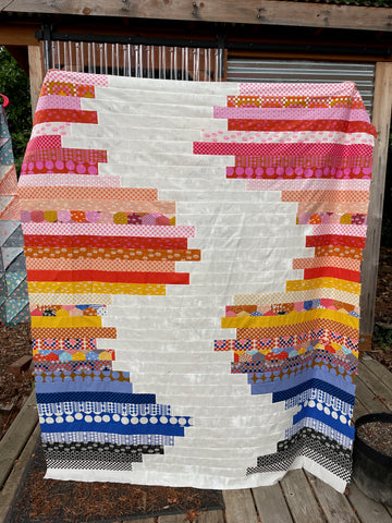 type it quilt top in pinks, oranges, blues, and blacks